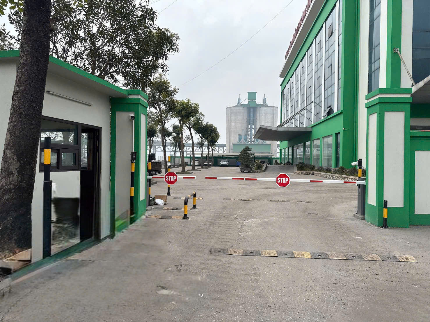 Cổng ra vào nhà máy với thanh chắn barie và biển báo dừng màu đỏ